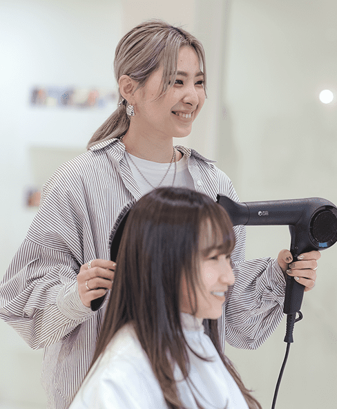 髪を乾かす女性美容師