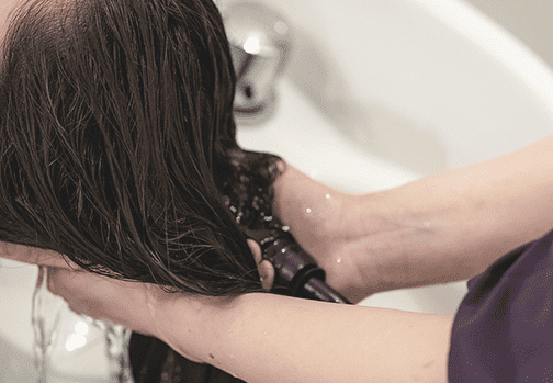 美容師で髪を洗っている画像
